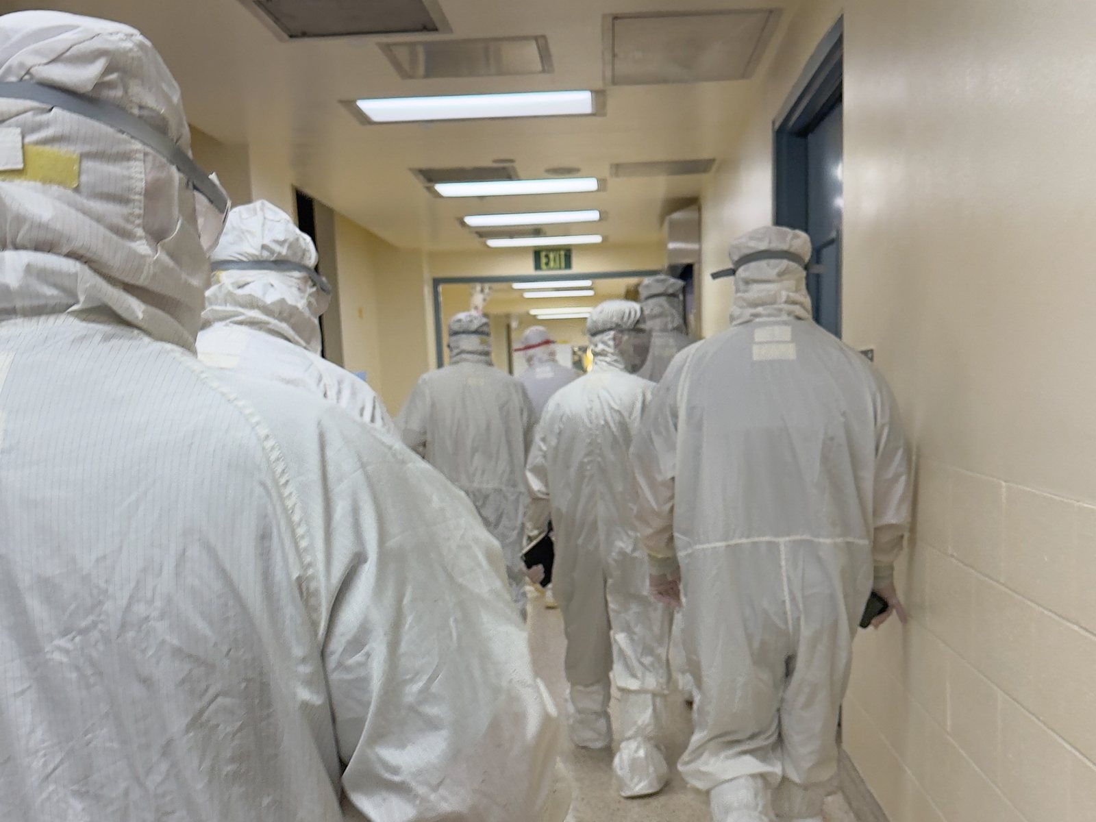 Personnel moving through the clean corridor toward the suite
